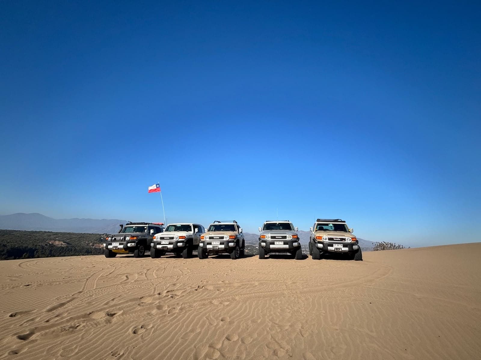 Convoy FJ Club Chile en las dunas, con la bandera de Chile